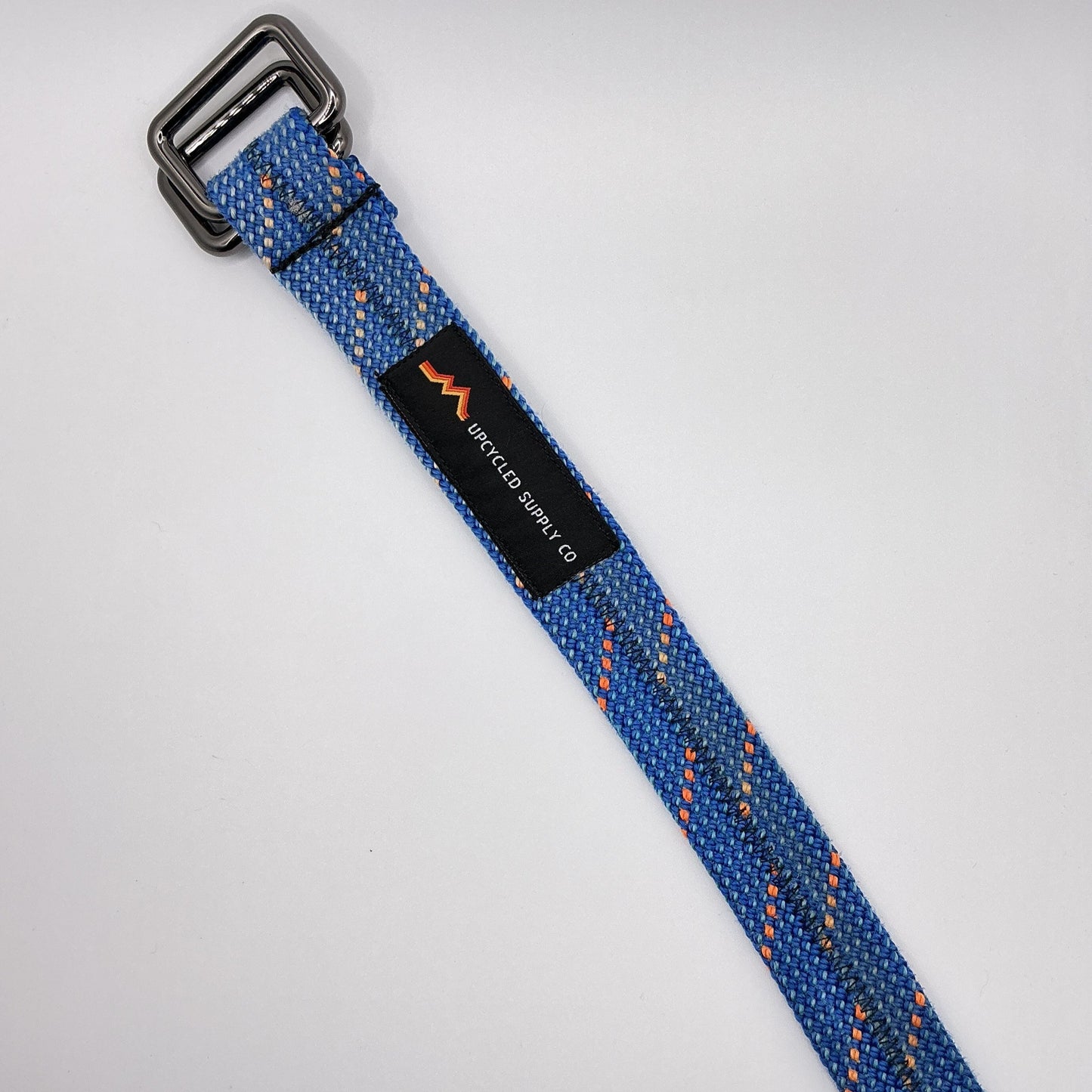 Blue woven belt with a metal buckle on a white background