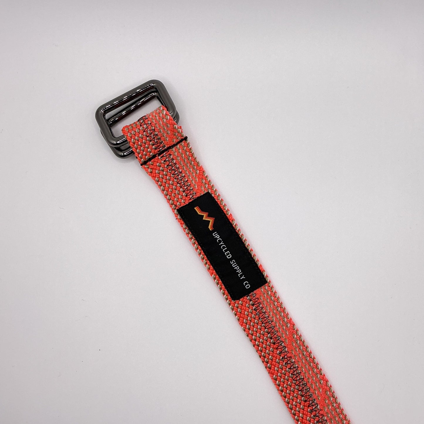 Red webbing strap with a black buckle on a white background