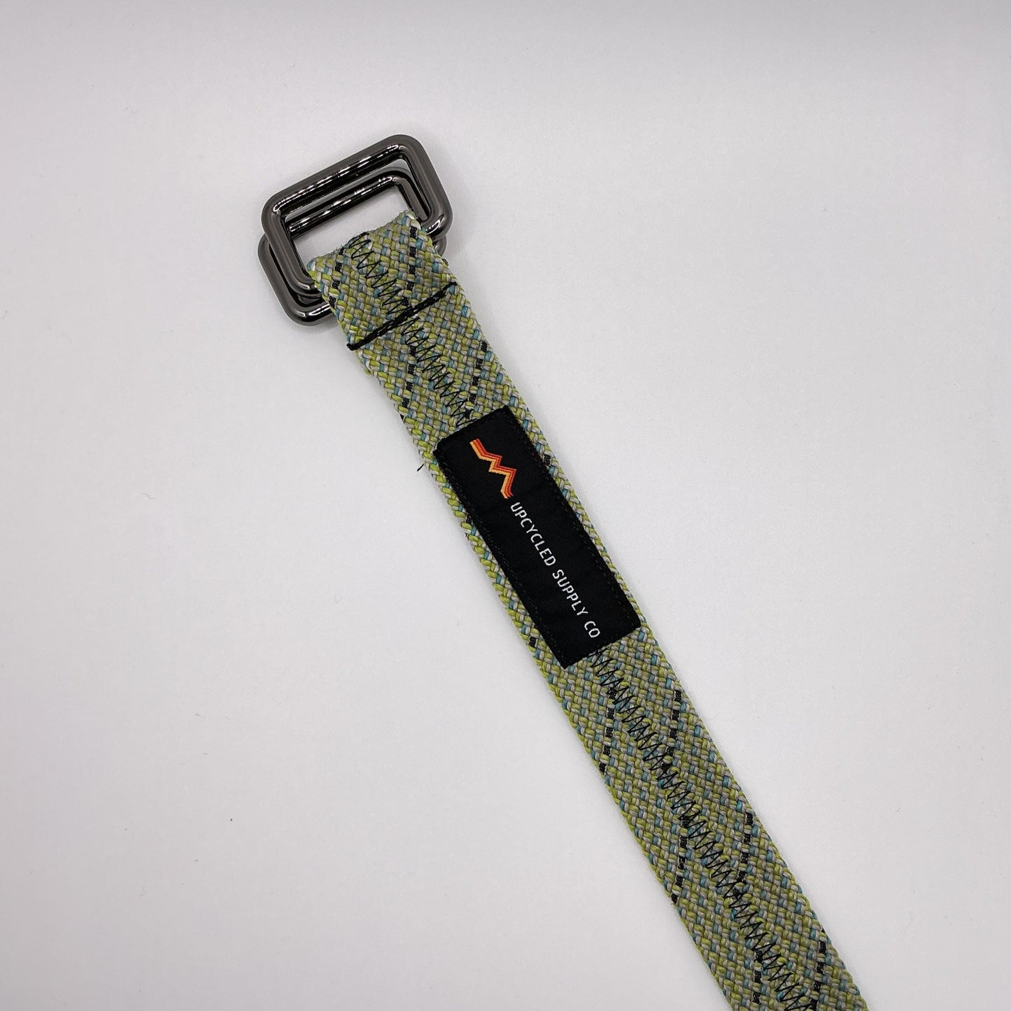 Green webbing strap with a black buckle on a white background