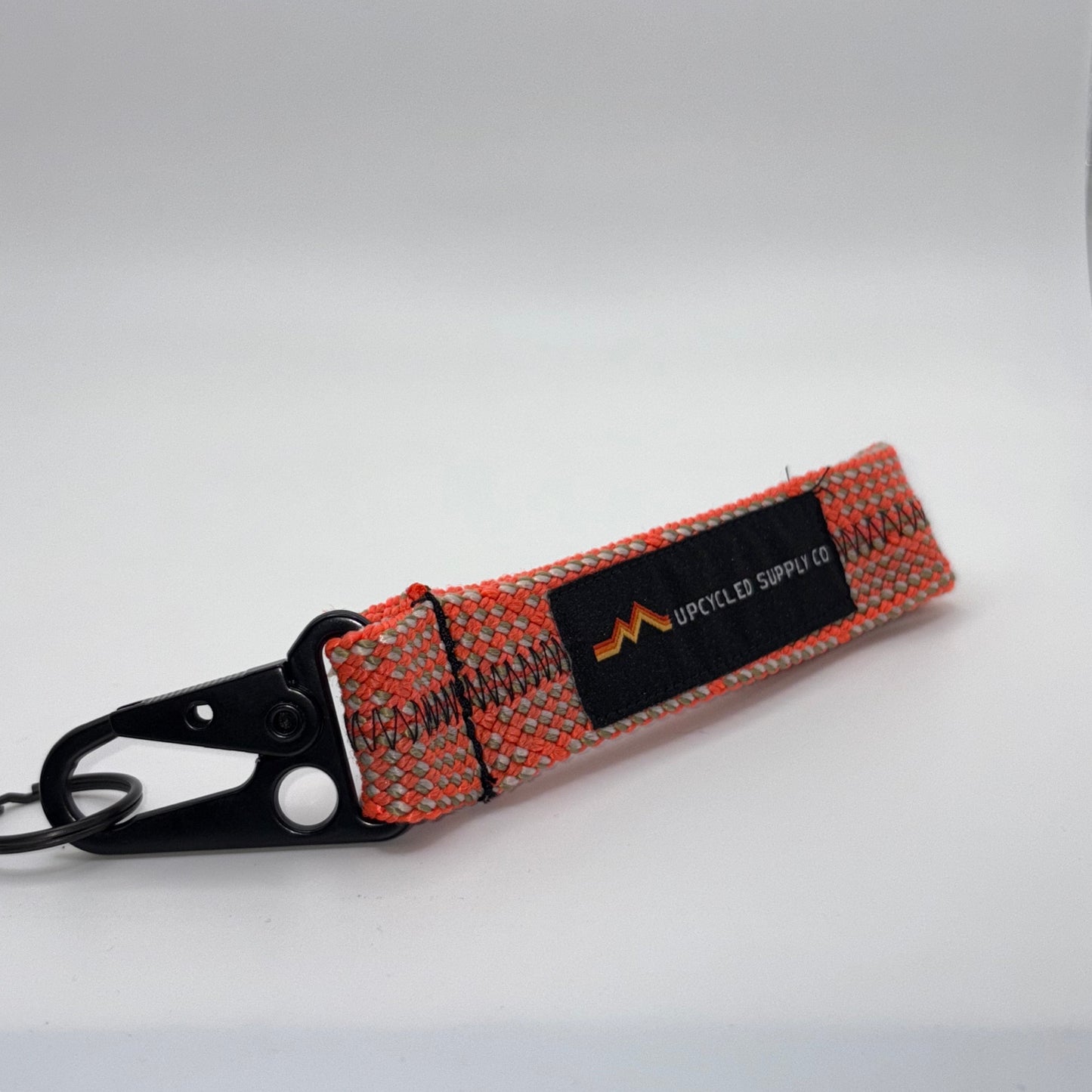 Orange and black strap with a brand label on a white background