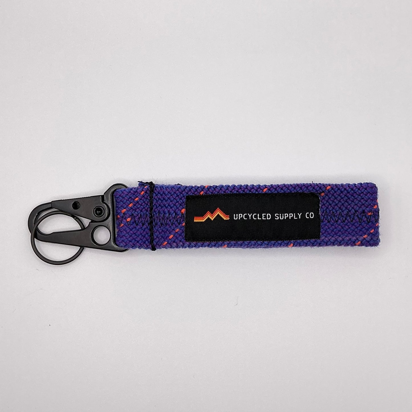 Purple keychain with a visible brand label on a light gray background