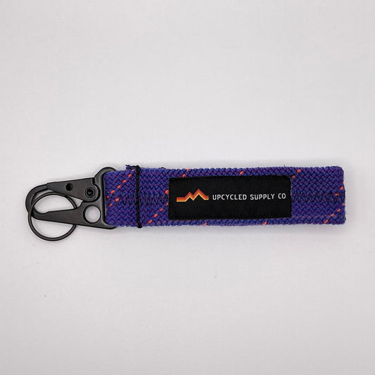 Purple keychain with a visible brand label on a light gray background