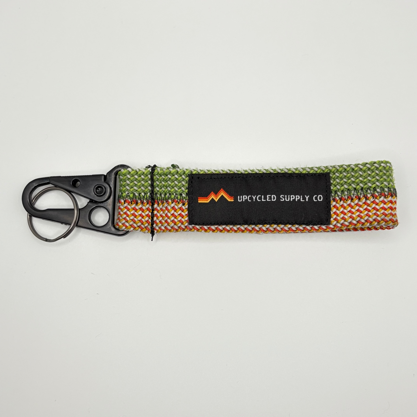 Keychain with colorful strap and black tag on a light gray background