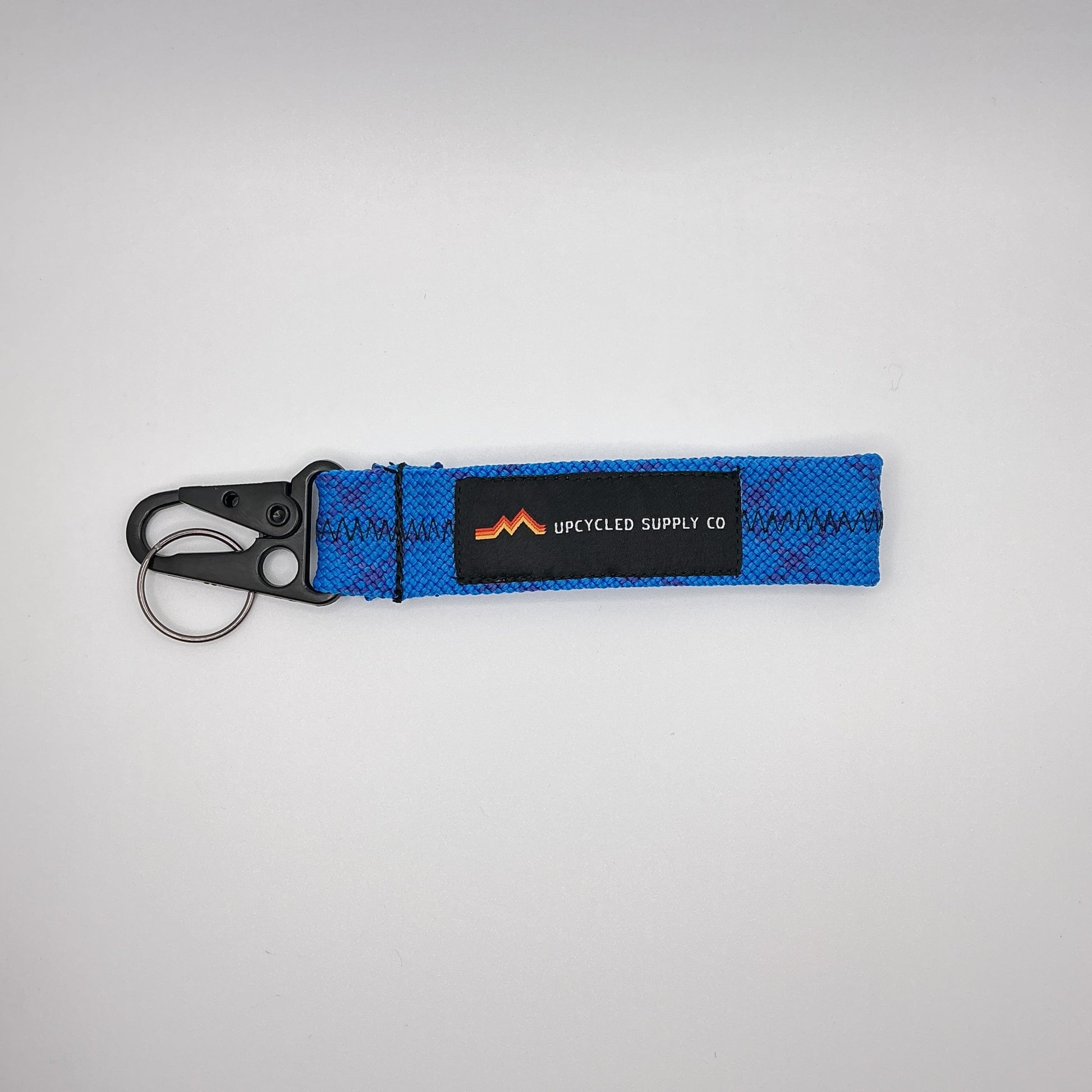 Blue keychain with a brand logo on a gray background