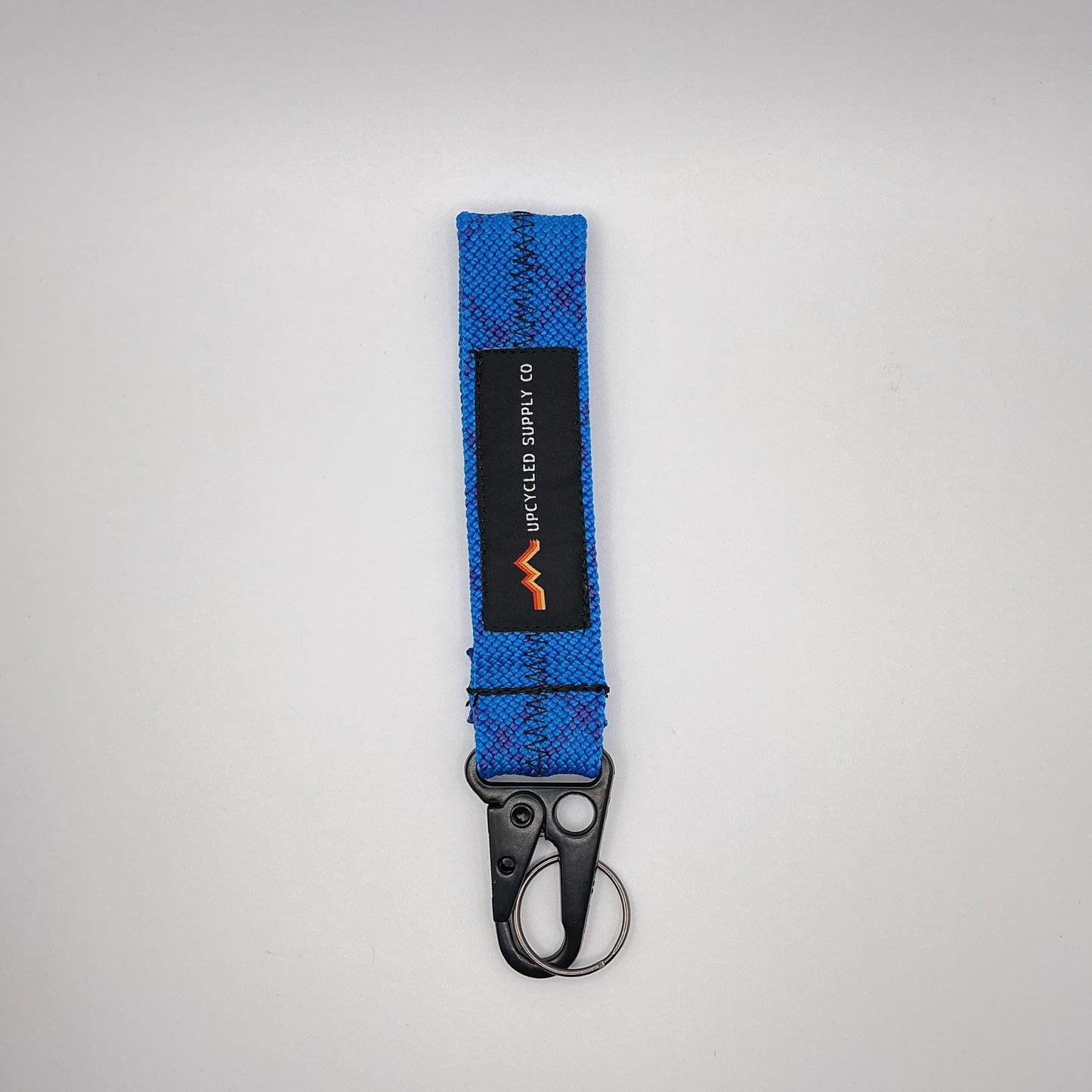 Blue keychain with a logo on a light gray background