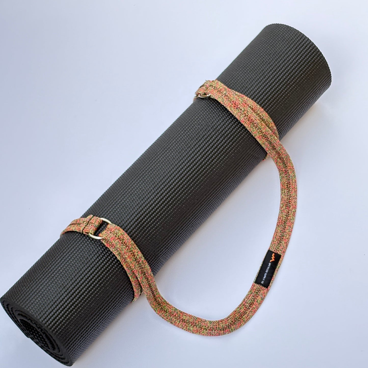 Black yoga mat with a cork strap on a white background