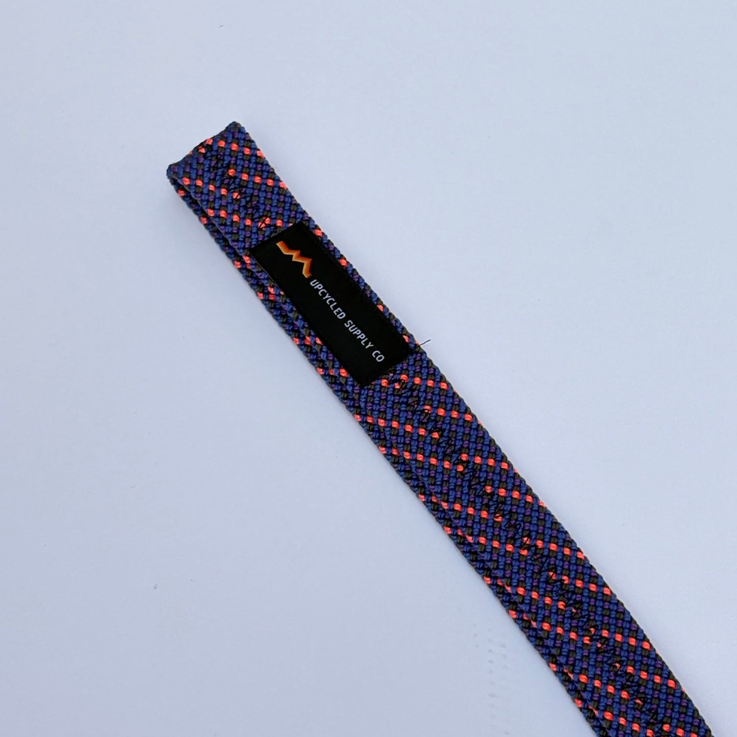 Textured tie with a brand label on a light gray background