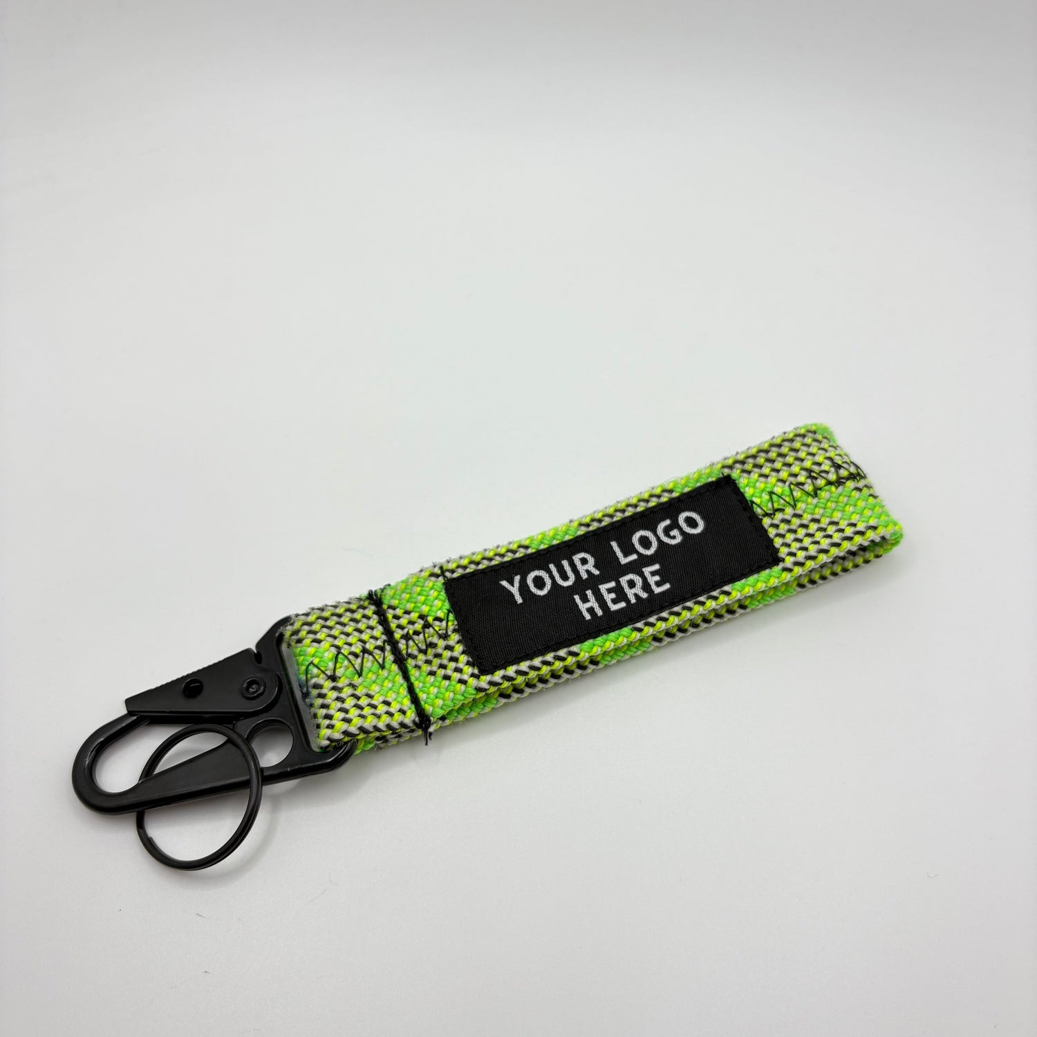 Green woven keychain with a customizable label on a gray background