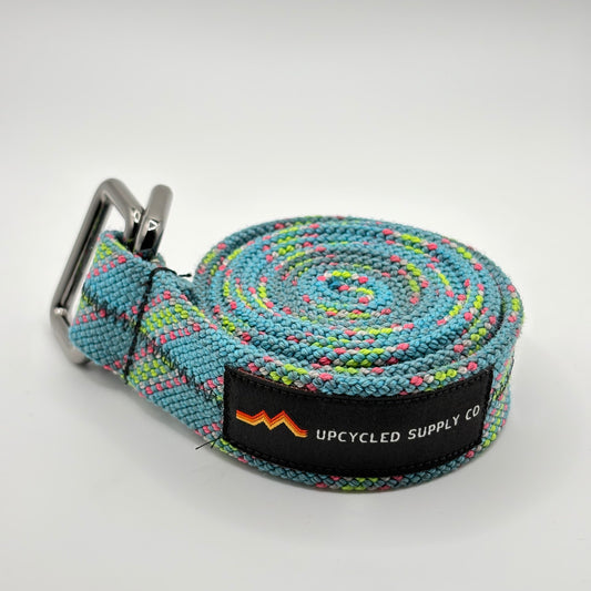 Multicolored striped belt with a metal buckle on a light gray background