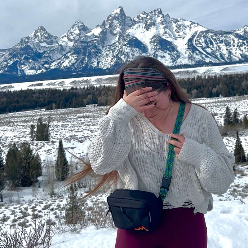 Person in a snowy landscape with mountains in the background