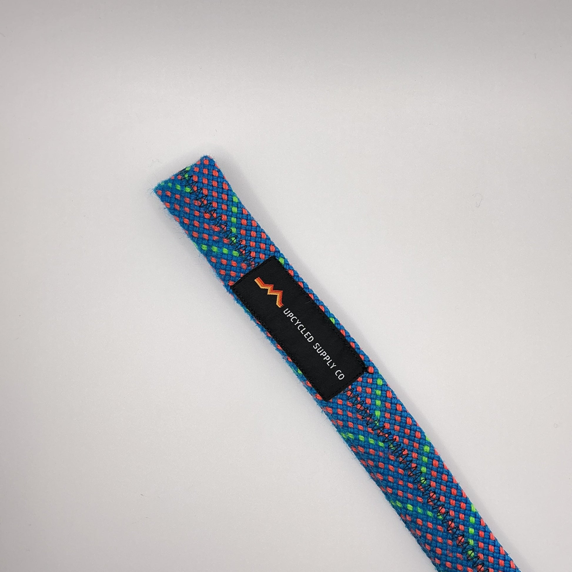 Multicolored textured strap with a brand label on a light gray background