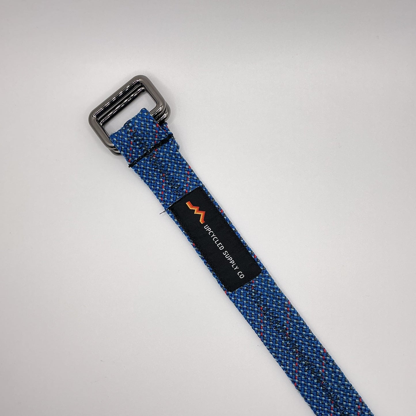 Blue woven strap with a buckle on a light gray background