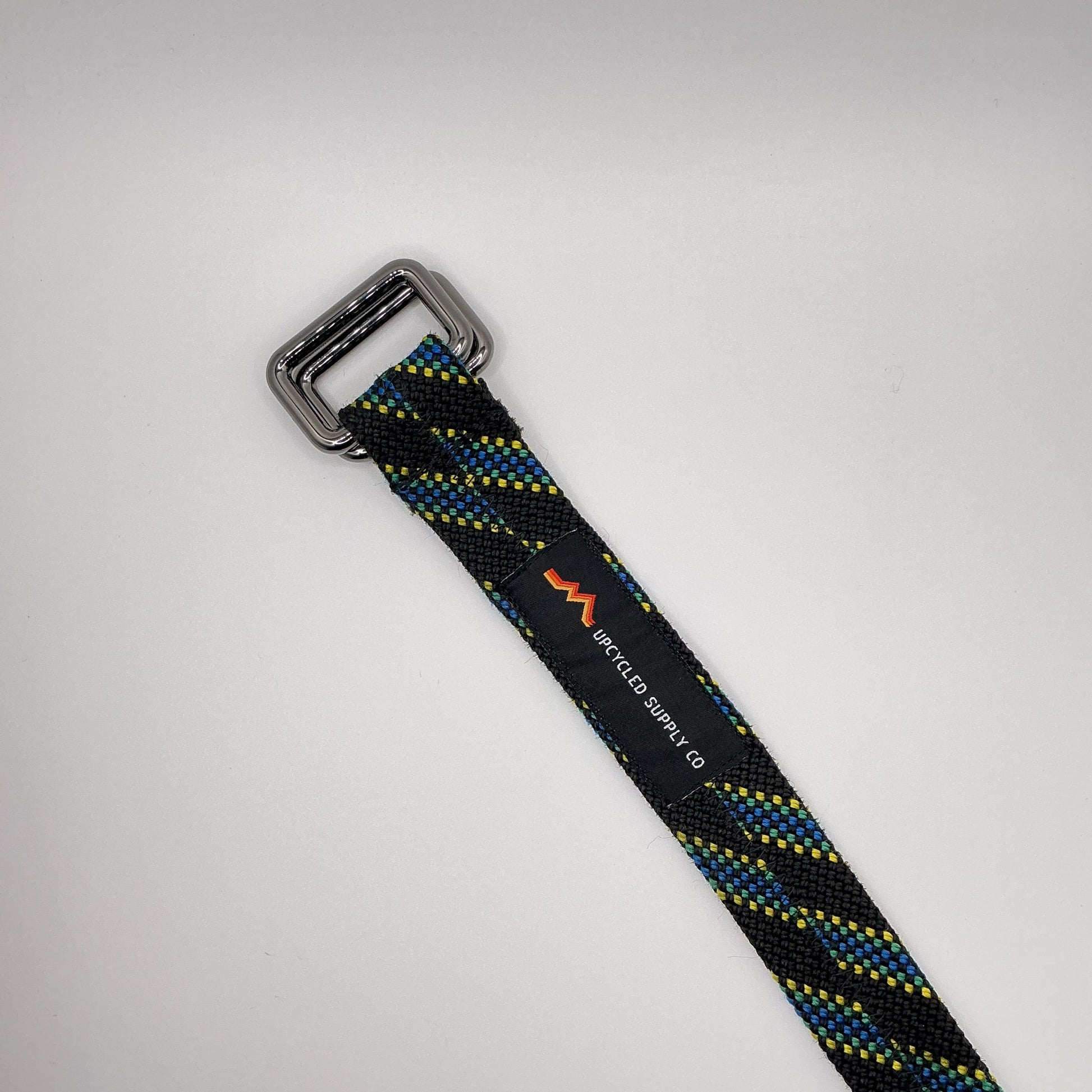 Black and blue striped strap with a metal buckle on a light gray background