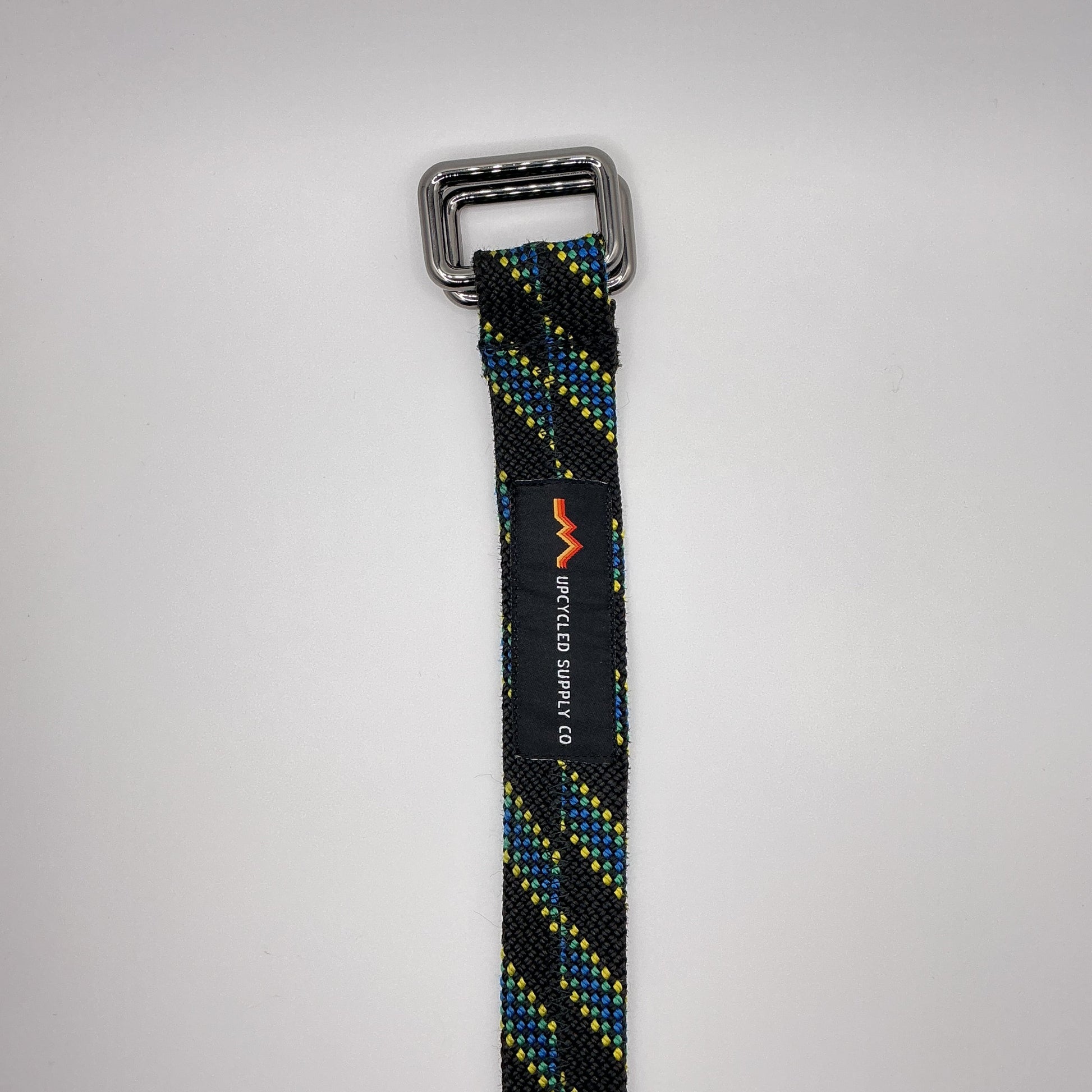 Black and yellow striped belt with a metal buckle on a gray background