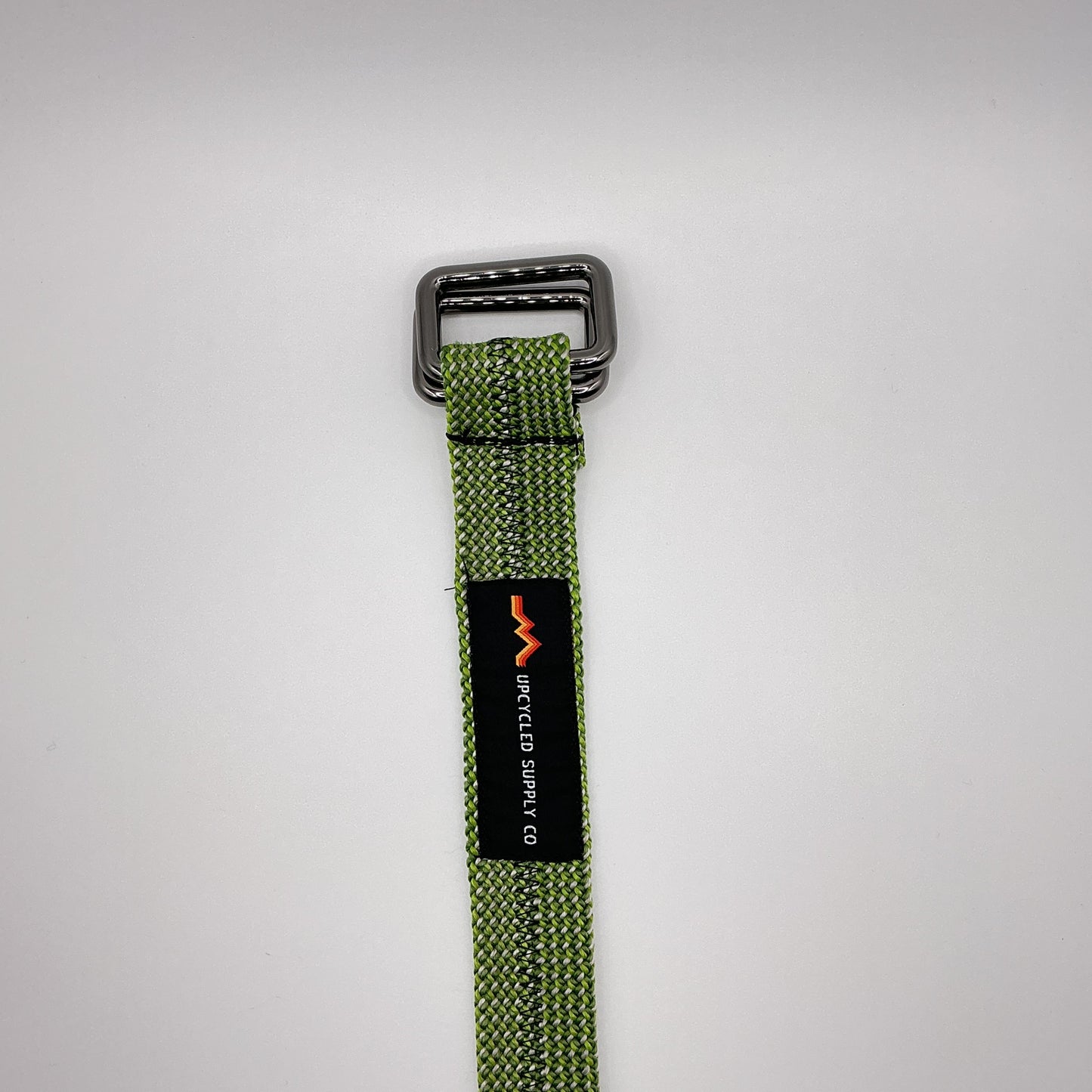 Green webbing strap with a black label on a gray background