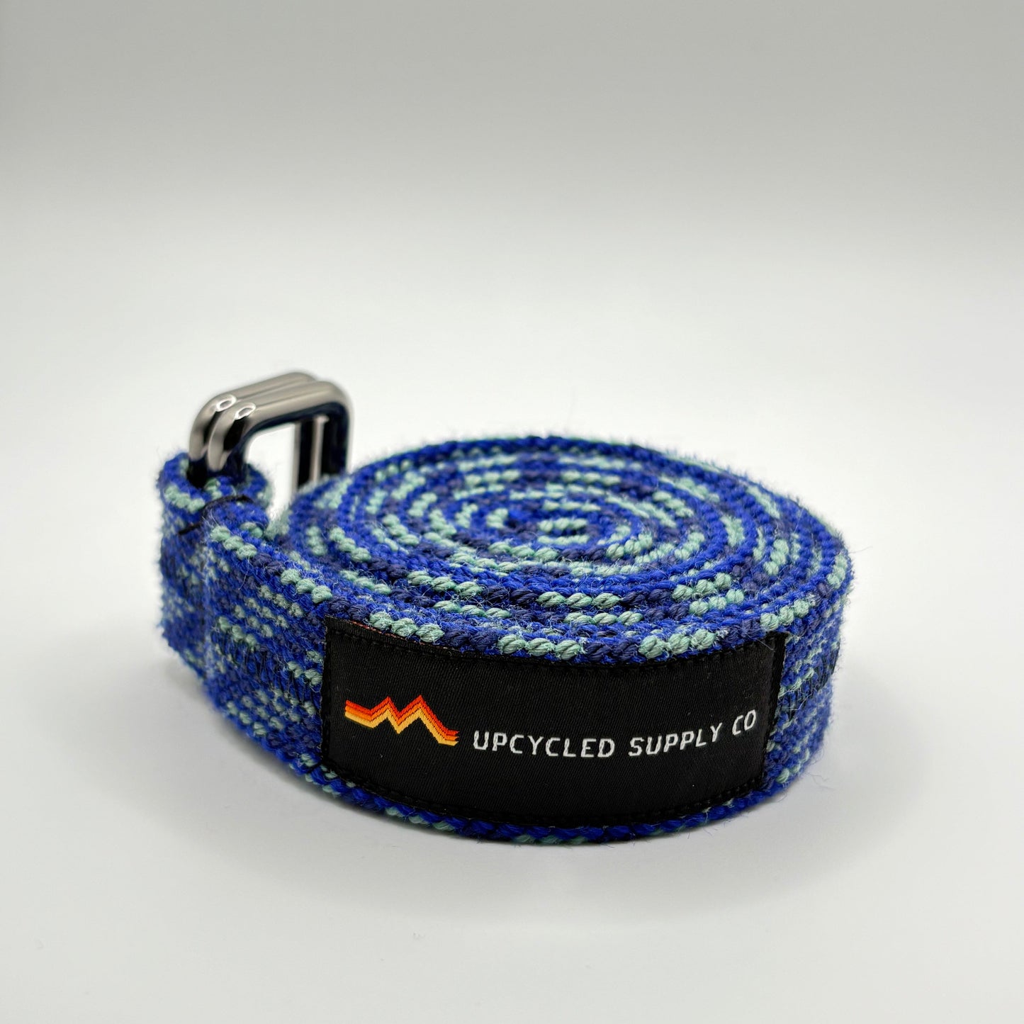 Blue and green striped yoga strap with a brand label on a white background