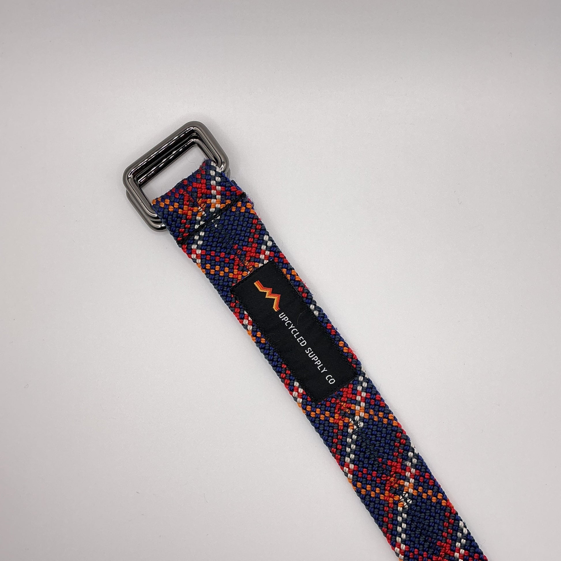Multicolored woven belt with a silver buckle on a light gray background