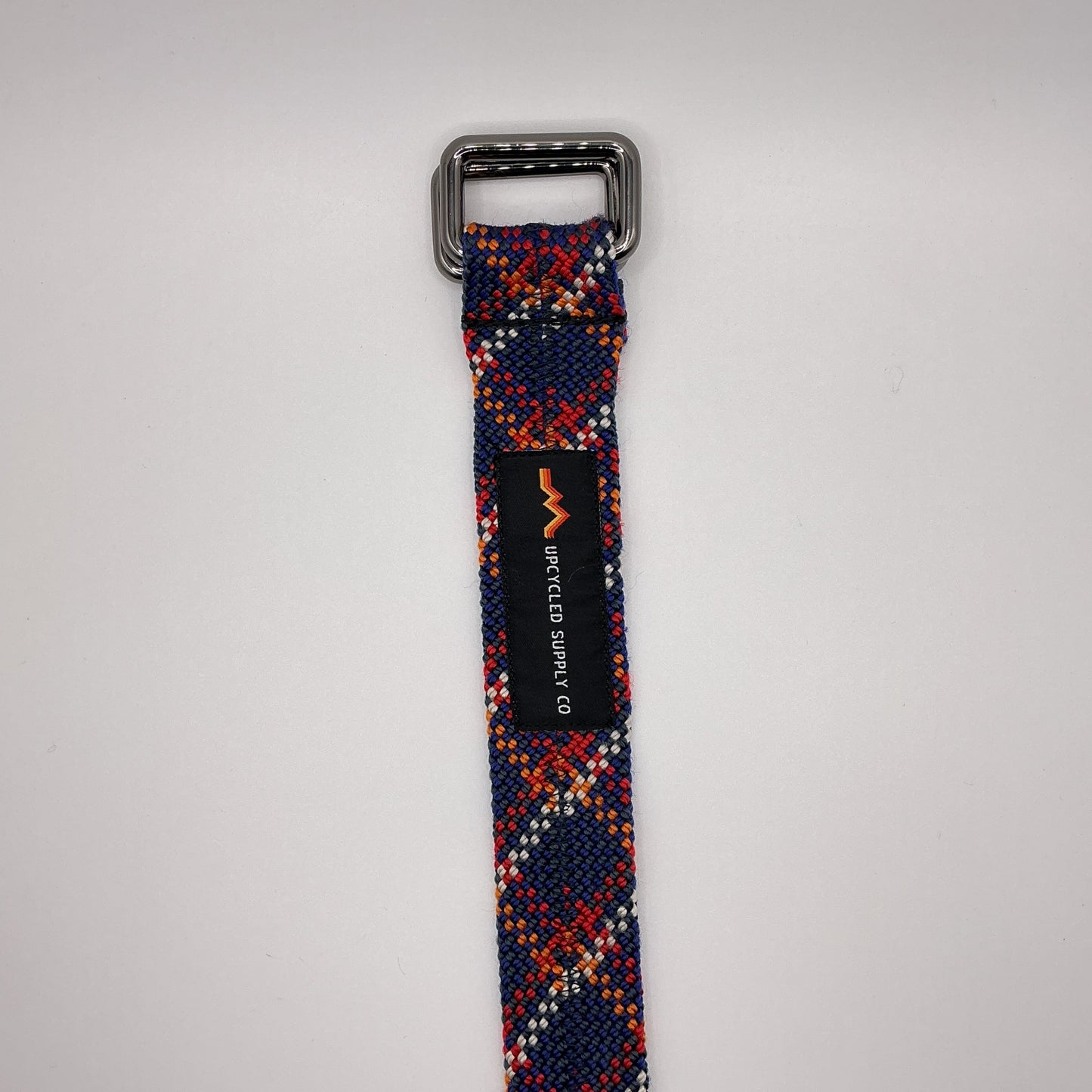 Multicolored patterned belt with a metal buckle on a gray background