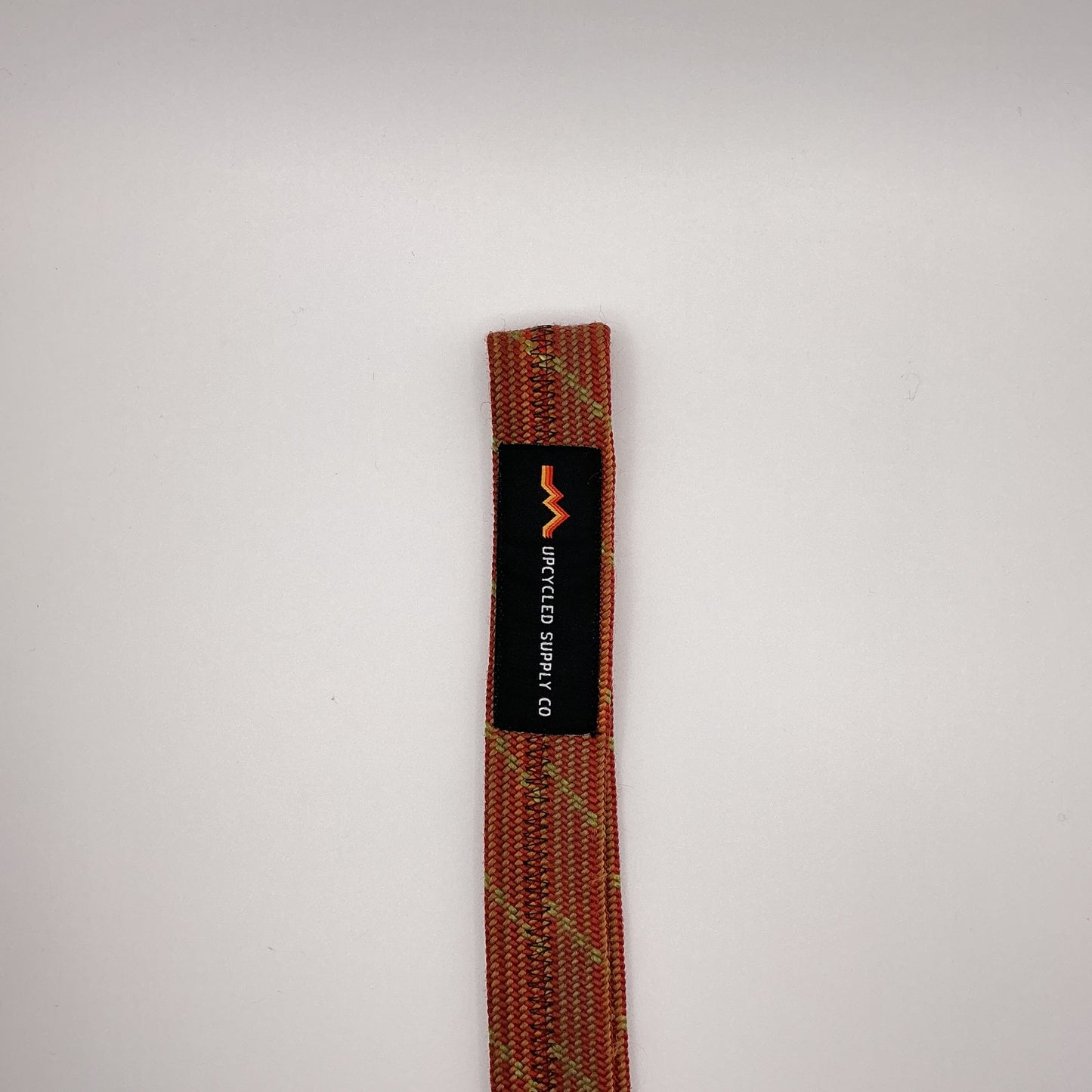 Textile strap with 'Upcycled Supply Co' label on a light gray background