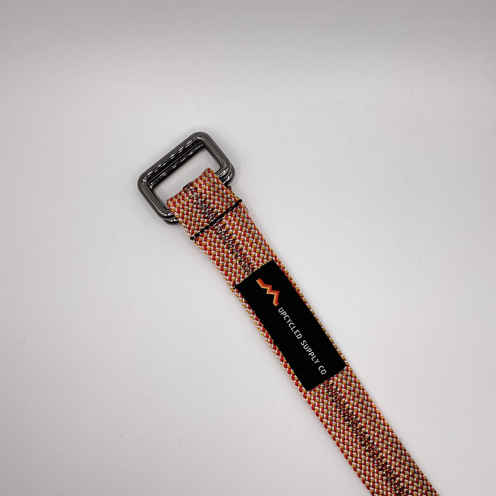 Woven belt with a black buckle on a light gray background