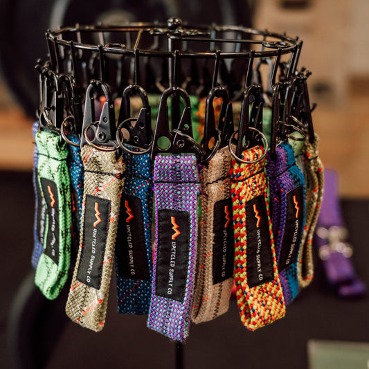 Collection of colorful keychains on a black stand with a blurred background