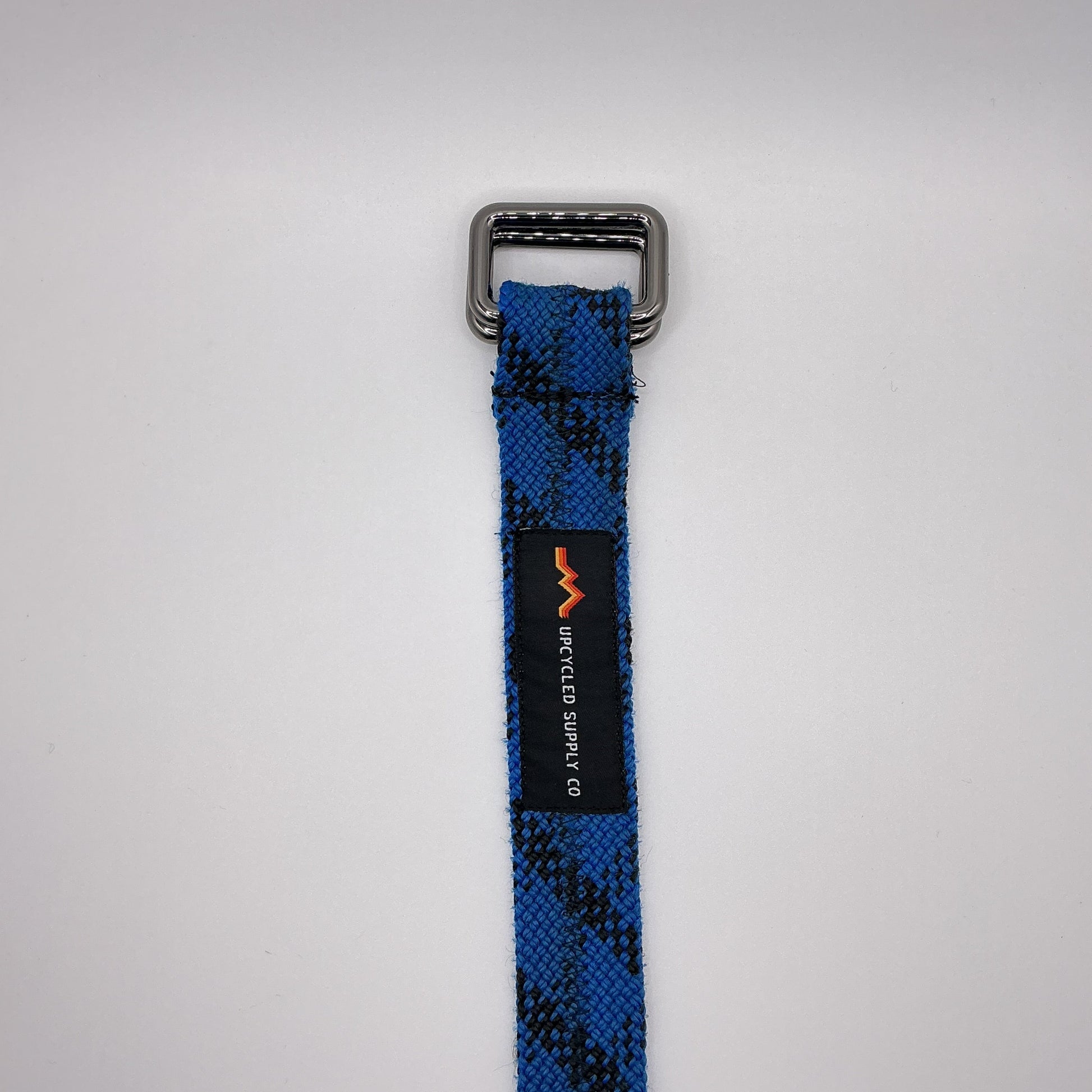 Blue and black checkered strap with a metal buckle on a light gray background
